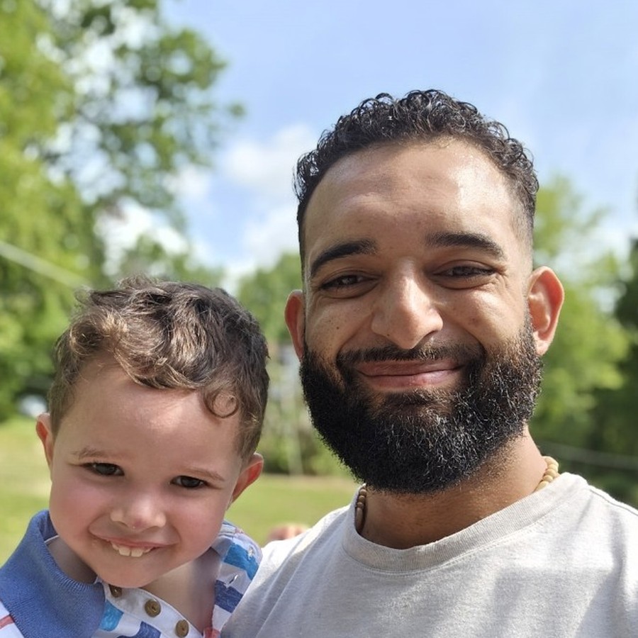 Miguel Caraballo smiling outdoors with his son